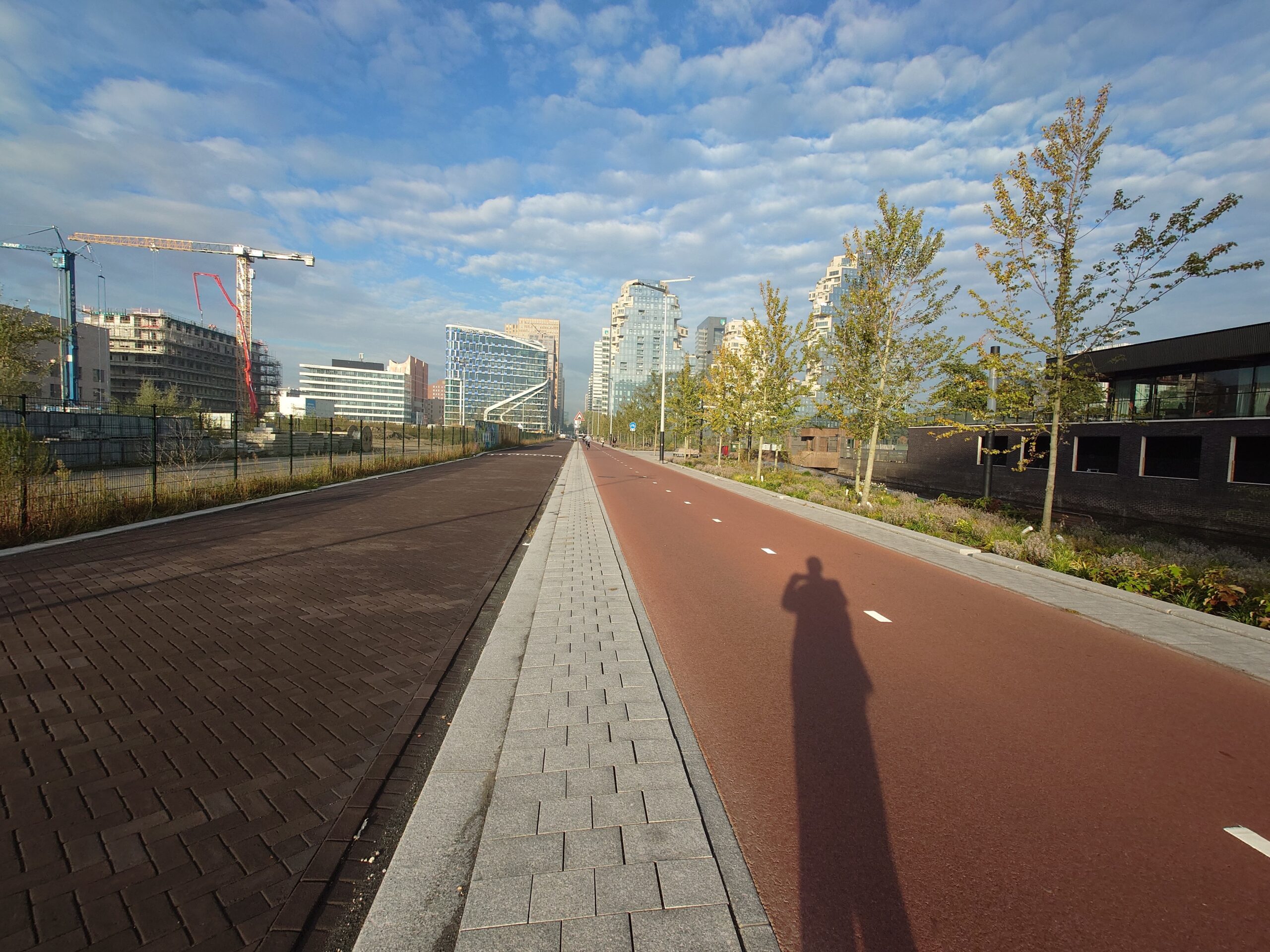 オランダの街路と青空に伸びる影。定年退職後に始まる新しい人生の道を象徴する風景。
